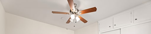 A room with a ceiling fan and wooden flooring.