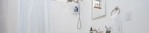 a bathroom with white walls and a white toilet next to a white vanity with a white sink