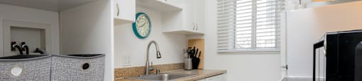 a kitchen with white cabinets and a white washer and dryer