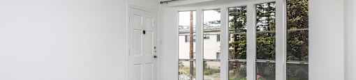 A room with a sliding door leading to a balcony.