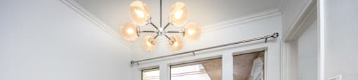A room with a grey floor and a chandelier.