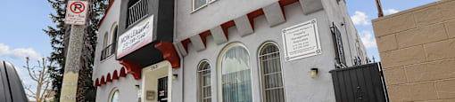 A white building with a red trim and a black door.