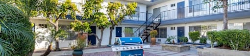 A blue and white object is in the middle of a courtyard with a white and red tiled floor.