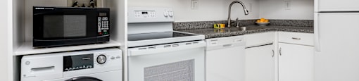 a kitchen with white cabinetry and a white tiled floor