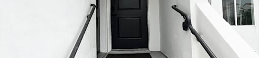 the entrance to a building with stairs and a black door