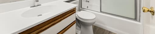 A white sink with a silver faucet is on a countertop in a bathroom.