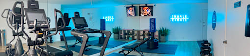 A gym with treadmills, exercise bikes, and dumbbells.