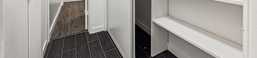 A white pantry with a door open to a bathroom.