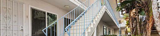 A white house with a blue staircase railing.