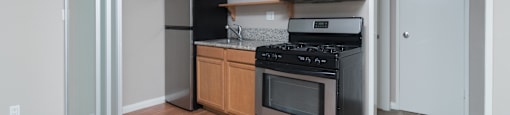 A kitchen with wooden cabinets and black appliances.