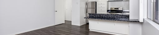 A kitchen with a refrigerator, microwave, and oven is visible.