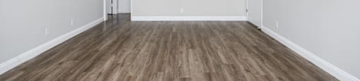 an empty living room with white walls and wood floors