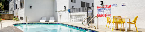 the pool of a building with yellow chairs and a swimming pool