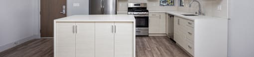 a kitchen with white cabinets and stainless steel appliances