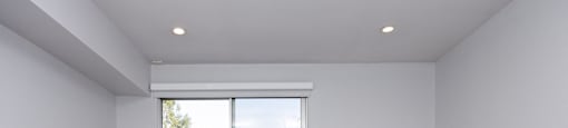 an empty living room with a sliding glass door to a balcony