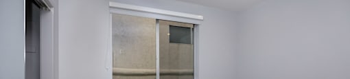 a room with white walls and a window and wood flooring