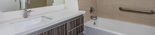 a bathroom with a tub and a sink and a mirror