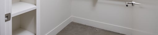 a walk in closet with white cabinets and shelves and
