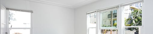 an empty living room with white walls and a wood floor