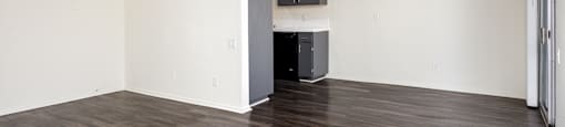 an empty living room with white walls and a ceiling fan