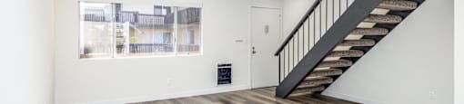 a living room with a staircase and a window