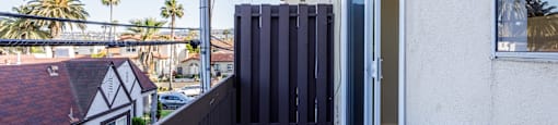 a balcony with a view of the city and a door to a patio