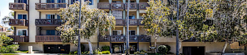 an apartment building with palm trees in front of it