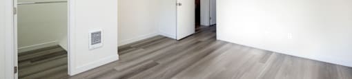 a renovated living room with white walls and wood flooring
