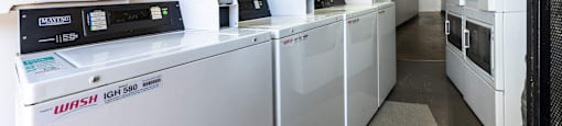 a row of washing machines in a room with a long line ofidges