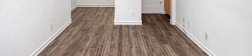 an empty living room with white walls and wood flooring