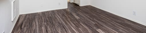 an empty living room with white walls and wood flooring