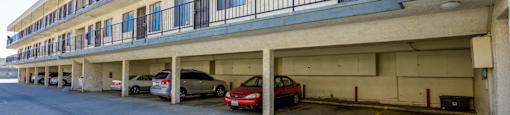 a parking garage with cars parked in front of a building