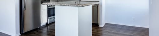 A kitchen with a refrigerator, sink, and stove.