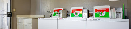 A row of washing machines are lined up in a laundromat.