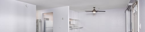 A room with a ceiling fan and wooden flooring.