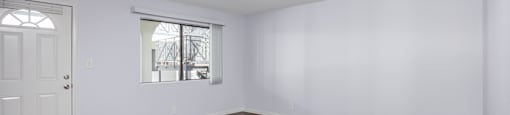 A room with wooden flooring and a window.