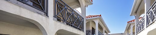 A long balcony with white columns and black railings.