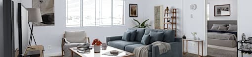A living room with a grey couch and a wooden coffee table.