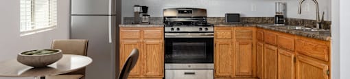A kitchen with wooden cabinets and a stainless steel refrigerator.