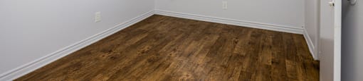 A room with a ceiling fan and wooden flooring.