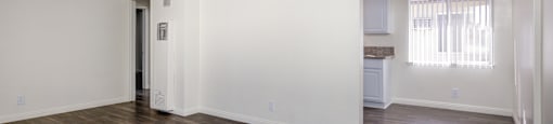 an empty living room with white walls and wood flooring