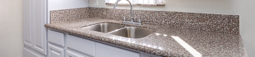a kitchen with white cabinets and granite counter top and a sink