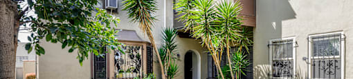 a house with a yard and palm trees in front of it