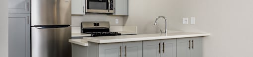 A kitchen with a stainless steel refrigerator and a white countertop.