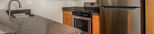 A kitchen with a stainless steel refrigerator and wooden cabinets.