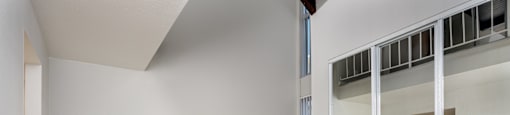 A room with a white wall and wooden floor.