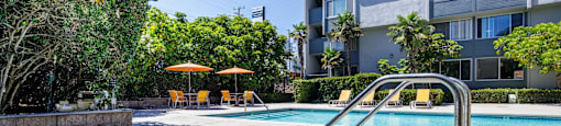 a hot tub in a pool with an apartment building in the background