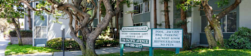 a sign in front of a building with trees