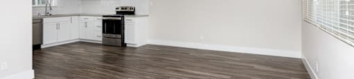 an empty kitchen and living room with a ceiling fan