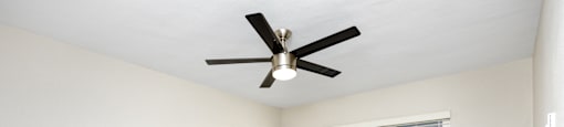 an empty room with a ceiling fan and a window